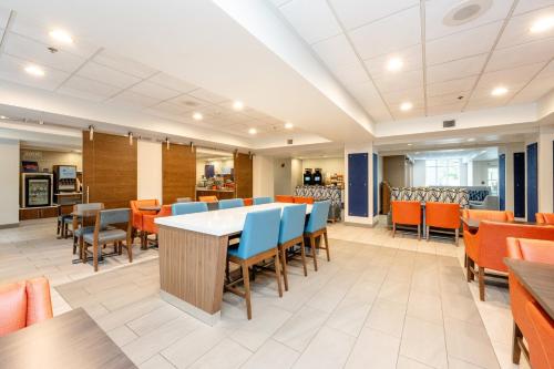 a dining room with a table and chairs at Holiday Inn Express Hotel & Suites Charleston-Ashley Phosphate by IHG in Charleston