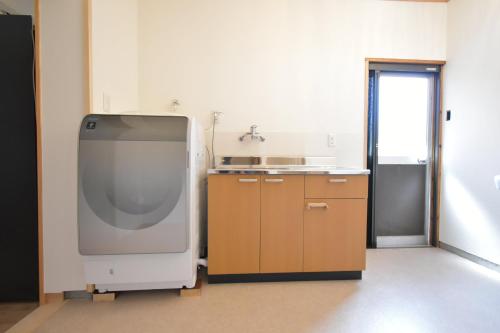 a kitchen with a large tv in a room at toit vert in Tanabe