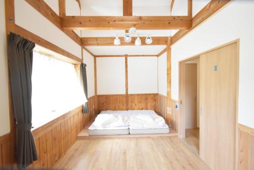 a bed in a room with a large window at toit vert in Tanabe