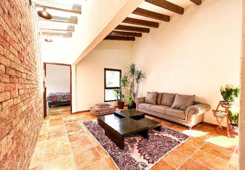 Una sala de estar con un sofá y una mesa de café. en Villa Lorena es un Lugar Magico para desconectarte, en Jalatlaco