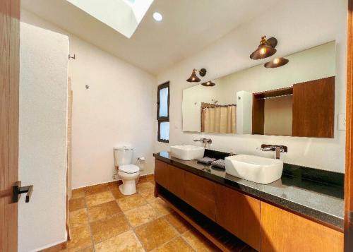 a bathroom with two sinks and a toilet at Villa Lorena es un Lugar Magico para desconectarte in Jalatlaco