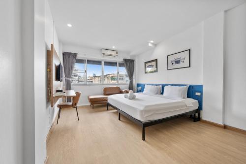 a bedroom with a bed and a couch and a chair at River View Residence in Bangkok