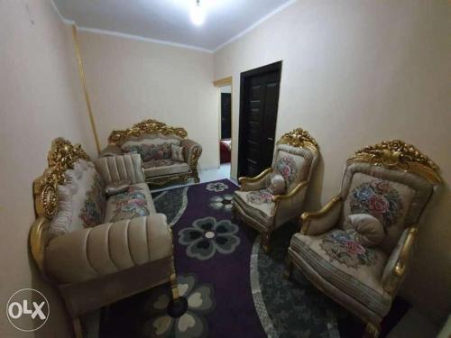 a living room with three chairs and a couch at Giza Pyramids Hotel in Cairo