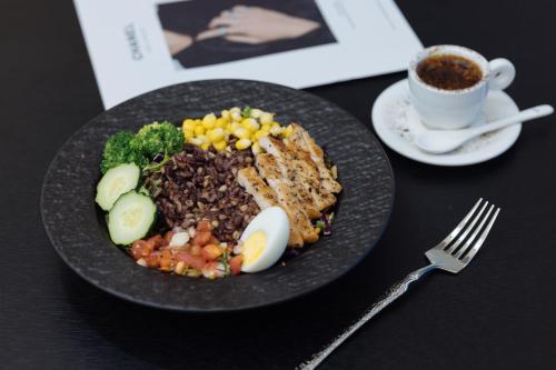 a plate of food with eggs and beans and a cup of coffee at SFEEL设计师酒店 Designer Hotel 昆明穿金路地铁站店 in Kunming