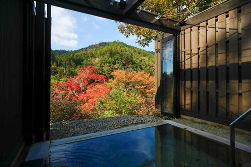 a house with a window looking out at a pool at Momijiya Honkan Takaosansou in Kyoto