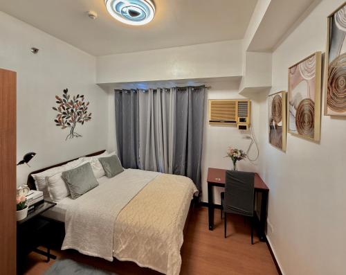 a hotel room with a bed and a desk and a desk at 1 Bedroom Bayview Condo near SLMEC & US Embassy in Manila