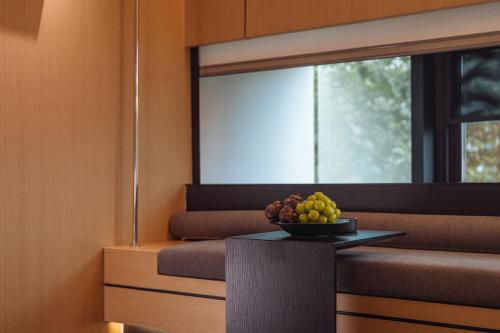 a bowl of fruit on a table in front of a window at SFEEL设计师酒店 Designer Hotel 昆明穿金路地铁站店 in Kunming