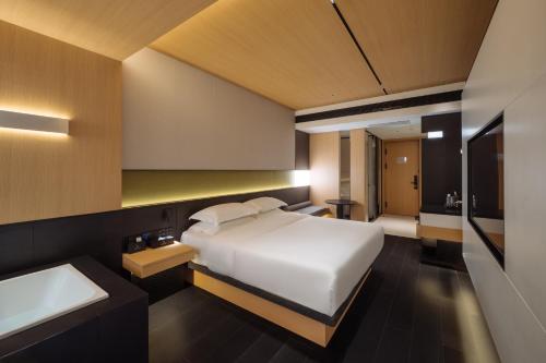 a bedroom with a bed and a sink and a tub at SFEEL设计师酒店 Designer Hotel 昆明穿金路地铁站店 in Kunming