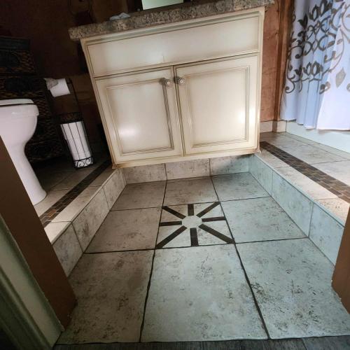 a bathroom with a white cabinet and a tiled floor at The God Spa in Redding