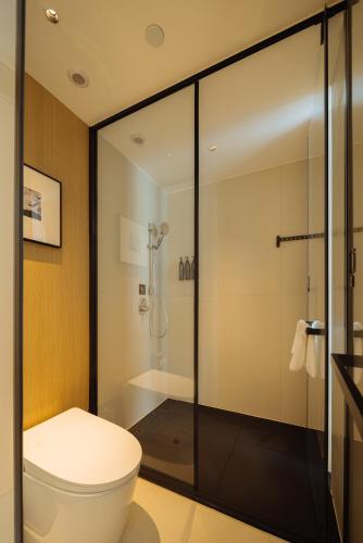 a bathroom with a toilet and a shower at SFEEL设计师酒店 Designer Hotel 昆明穿金路地铁站店 in Kunming