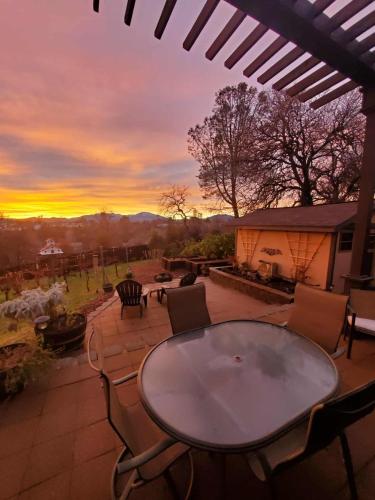 a table and chairs on a patio with a sunset at The God Spa in Redding