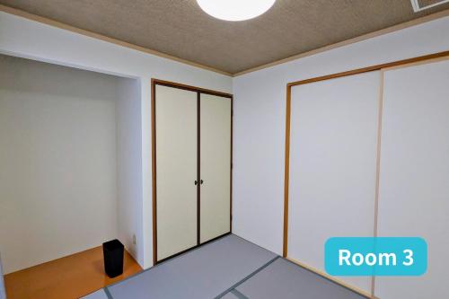 a room with white walls and wooden closets at Vacation House 1 in Funabashi