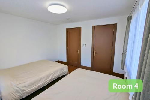a bedroom with two beds and a window at Vacation House 1 in Funabashi