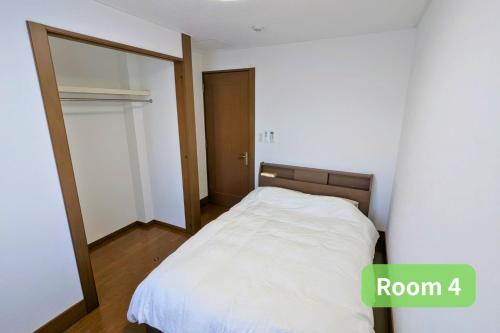 a small bedroom with a bed and a mirror at Vacation House 1 in Funabashi