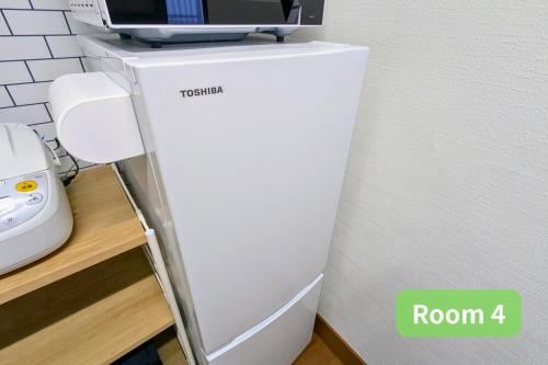 a white refrigerator sitting next to a wall at Vacation House 1 in Funabashi