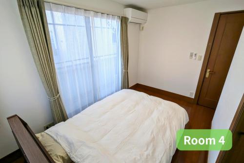 a small bedroom with a bed and a window at Vacation House 1 in Funabashi