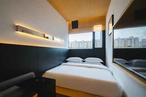 a bedroom with a white bed and a window at SFEEL设计师酒店 Designer Hotel 昆明穿金路地铁站店 in Kunming