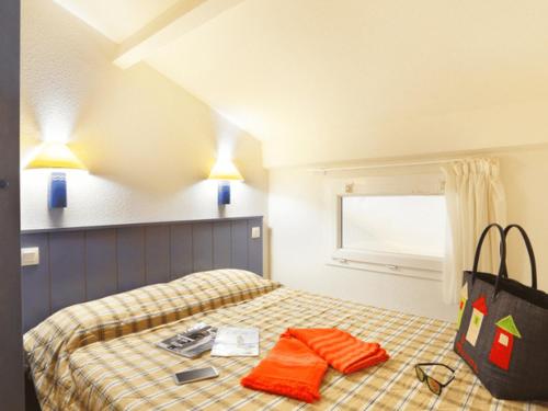 ein Schlafzimmer mit einem Bett mit einer Tasche darauf in der Unterkunft Appartement avec Terrasse pour 4 personnes à Saint-Georges-d'Oléron - API-1-52-630 in Saint-Georges-dʼOléron