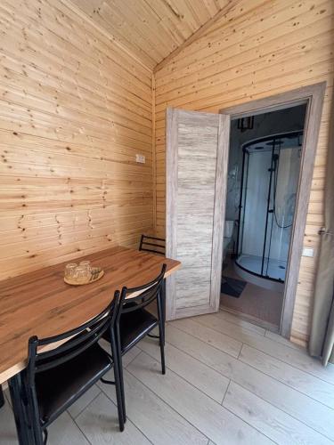 a wooden table and chairs in a room with a wooden wall at Jargylchak-Sunrise in Kichi-Jargylchak