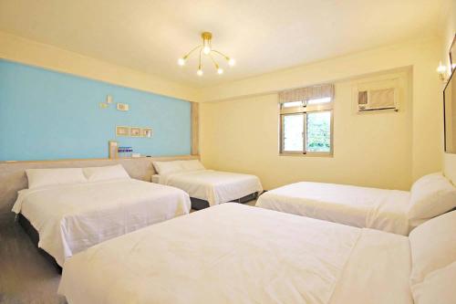 a hospital room with three beds and a window at Horizon in Green Island