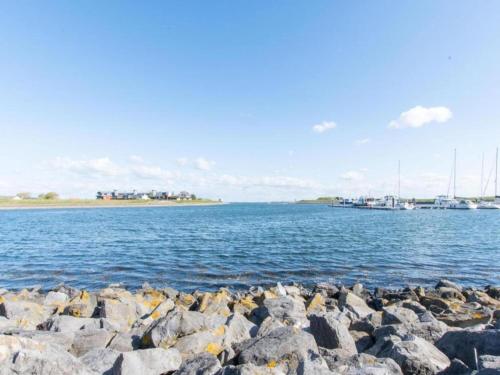 a large group of rocks in the water with boats at Cozy Seaside Retreat in Zeeland in Wemeldinge