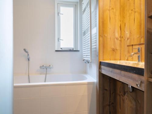 a bathroom with a tub and a sink at Brabant Holiday Home With Sauna 