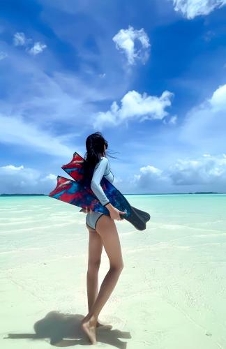 a woman standing on a beach with a kite at Horizon in Green Island
