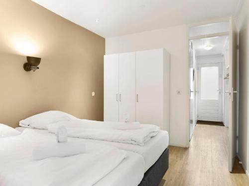 two beds in a room with white walls at Wooded Park Retreat in Drenthe in Midlaren
