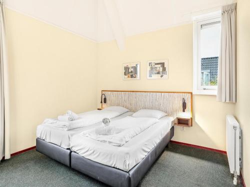 two beds in a room with two windows at Holiday Home Near Groningen City in Midlaren