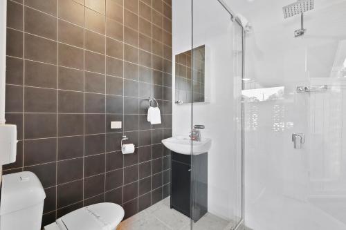 Un baño con ducha, inodoro y lavabo. en Funky Lil Shack - by the jetty, en Bongaree