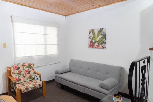 a living room with a couch and a chair at 100 Wonderful House in Bogotá