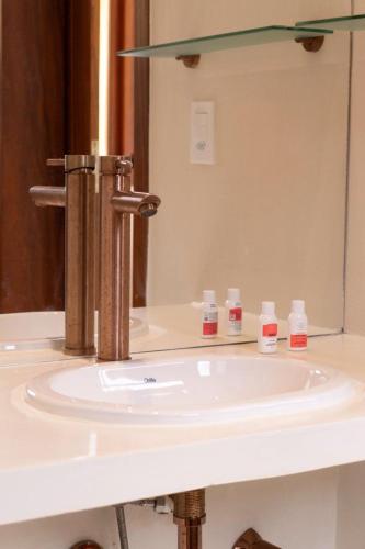 a bathroom sink with a faucet and a mirror at Morro de São Paulo- Quarta Praia - Casa Bethel in Cairu