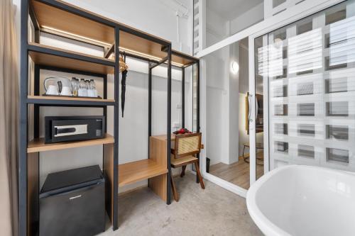 a bathroom with a white tub and a sink at River View Residence in Bangkok