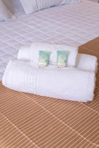 a stack of white towels on a bed at Morro de São Paulo- Quarta Praia - Casa Bethel in Cairu