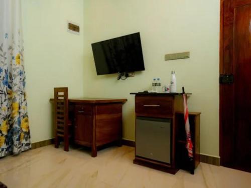 a living room with a flat screen tv on a wall at Infenta's Villa in Pandattarippu