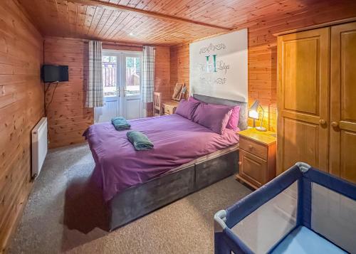 a bedroom with a bed in a wooden cabin at Heronstone Lodges in Ystalyfera