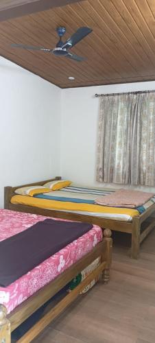 2 letti in una camera con soffitto di His Grace Holiday Home - Nr to Malpe Beach a Udupi