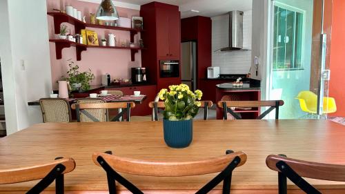 a wooden table with a vase of flowers on it at Casa do Lago em Londrina in Londrina