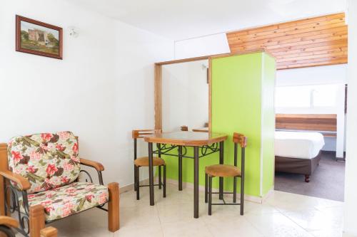 a room with a table and a chair and a bed at 100 Wonderful House in Bogotá