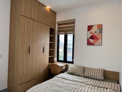 a bedroom with a bed and a wooden cabinet at Dreams Homestay with Full Kitchen & Big Lounge in Hue