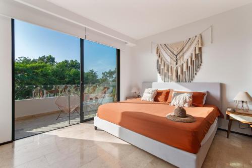 Un dormitorio con una cama grande y un balcón. en Vibra Bonito - Boho Chic Studio with Rooftop & Infinite Pool, en Tulum