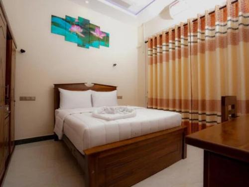 a bedroom with a bed and a desk in it at Infenta's Villa in Pandattarippu