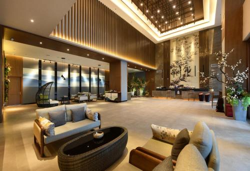 a lobby with couches and tables in a building at Mehood Lestie Hotel Chengdu Hi-Tech Zone in Chengdu