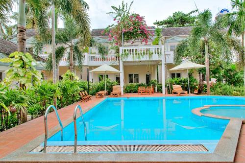 a pool in front of a house with palm trees at S79 Blue in Phu Quoc