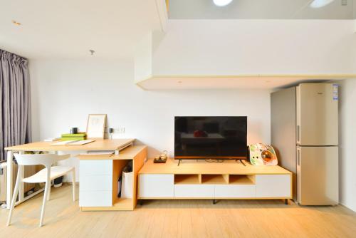 a kitchen with a desk with a television and a refrigerator at Dabaizhijia Executive Apartment Bantian Huawei Branch in Shenzhen