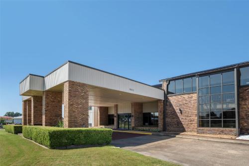 a large brick building with a large window at SureStay Plus Hotel by Best Western Greenwood in Greenwood