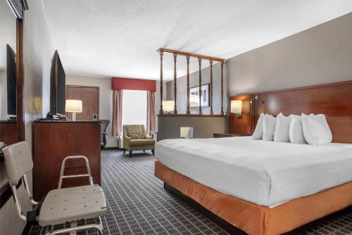 Una habitación de hotel con una cama grande y una silla. en SureStay Plus Hotel by Best Western Greenwood, en Greenwood