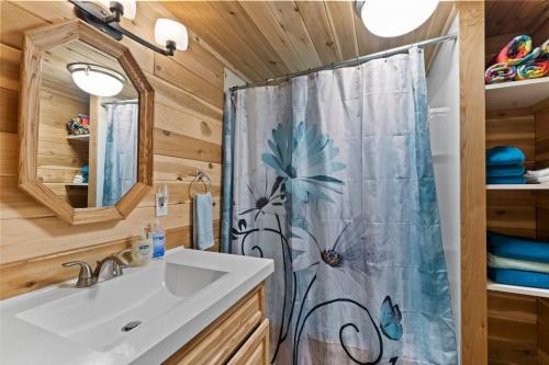 a bathroom with a sink and a shower curtain at Rainier Vintage Retreat With Hot Tub-Fireplace-WiFi in Ashford