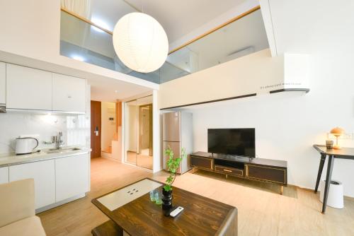 a living room with a table and a kitchen at Dabaizhijia Executive Apartment Bantian Huawei Branch in Shenzhen