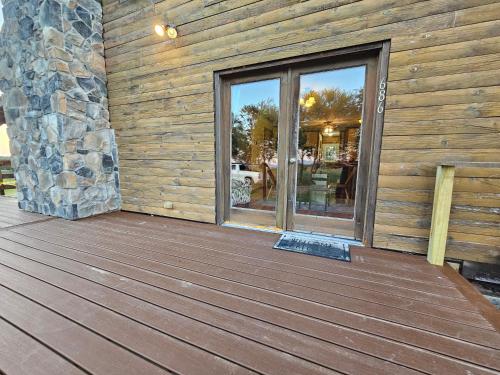 a wooden deck with a glass door on a building at Modern Log House First Level Primary in Winchester
